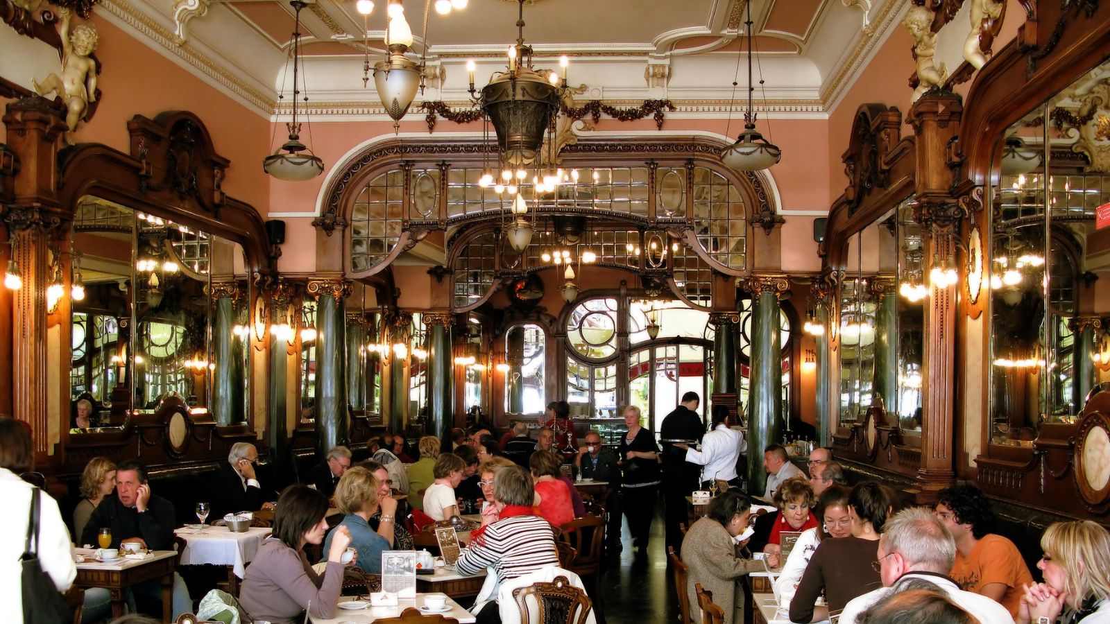 nhiều con người đang thưởng thức cà phê tại quán cafe đẹp nhất thế giới - Café Majestic, Porto, Bồ Đào Nha