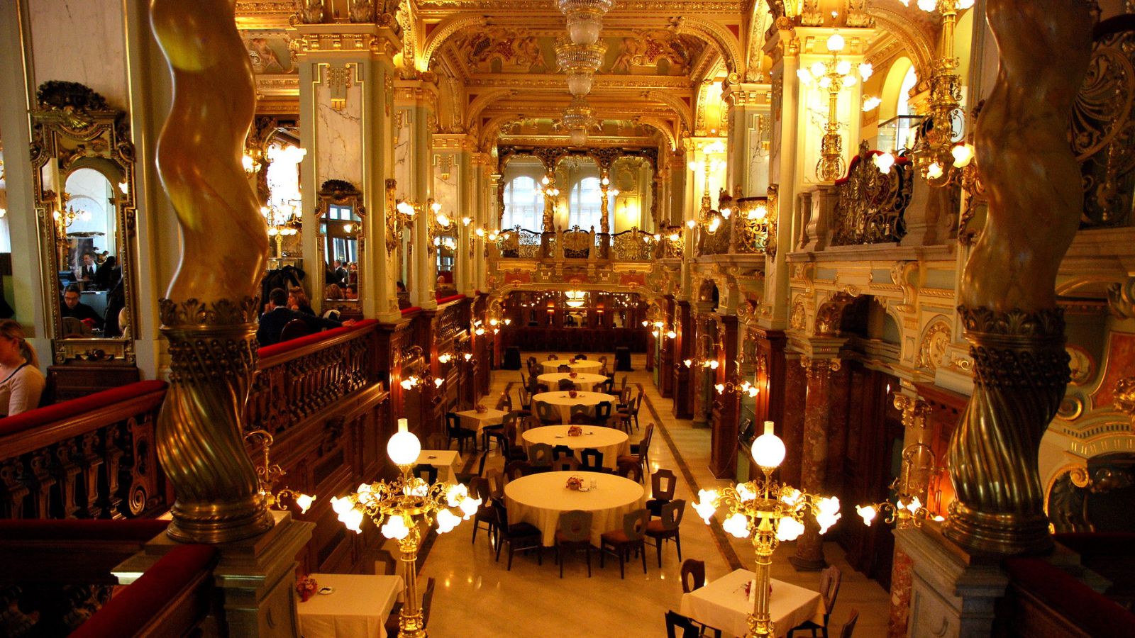 không gian ánh đèn vàng, chính diện là các bàn tròn tại quán New York Cafe đẹp nhất thế giới 
